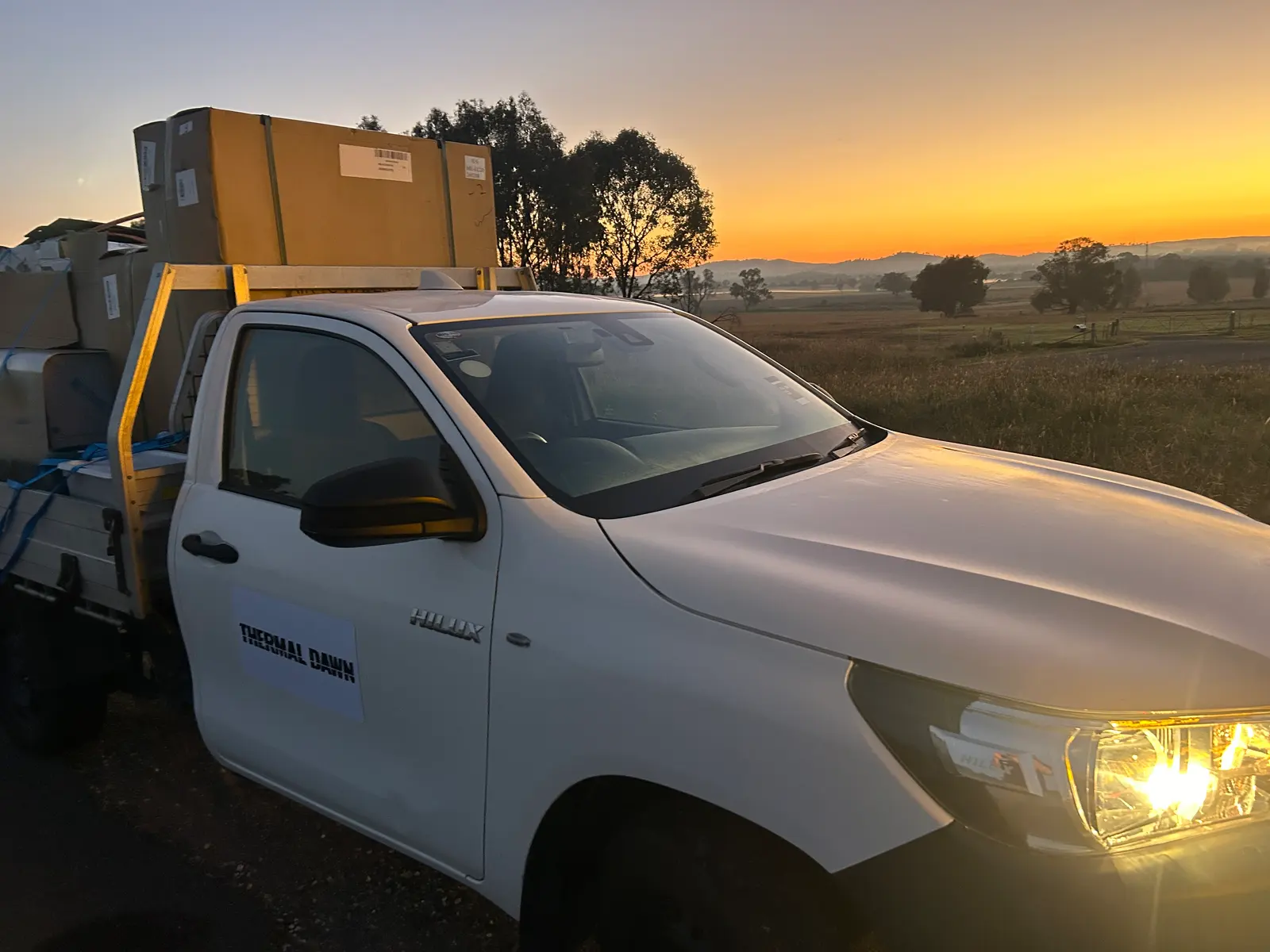 The branded Thermal Dawn ute at sunrise, loaded with crated systems for an install